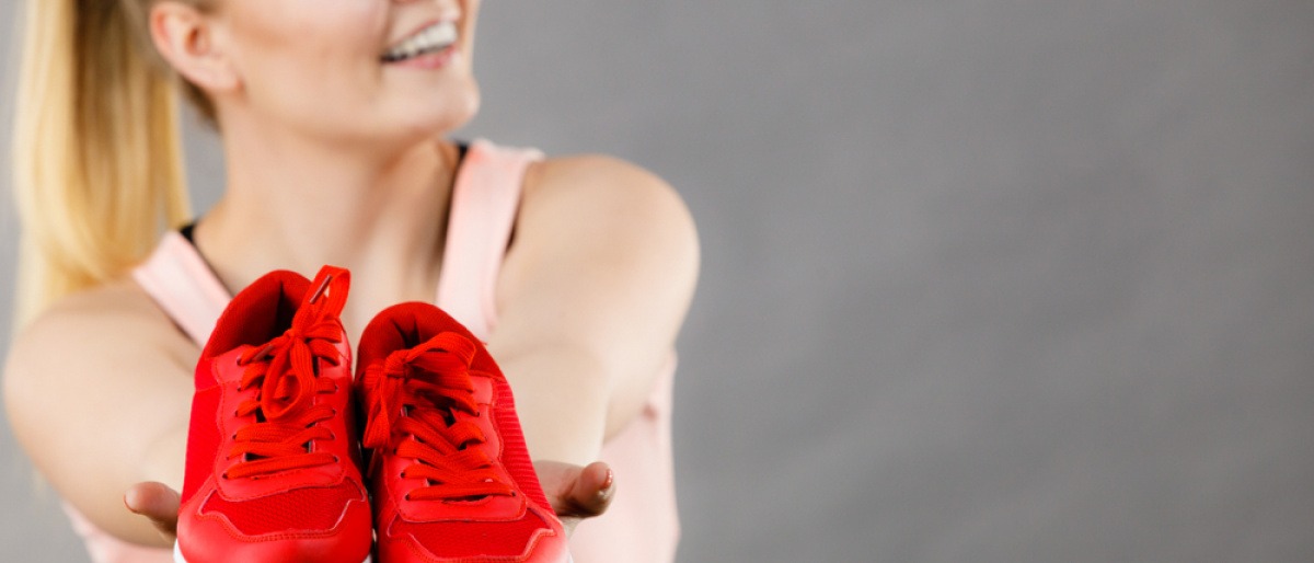 Frau präsentiert stolz ihre Sneaker, die sie gerade mit Hausmitteln wasserdicht gemacht hat.