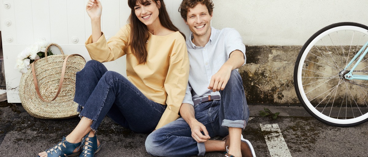 Ein Mann und eine Frau sitzen mit Schuhtrends Sommer 2019