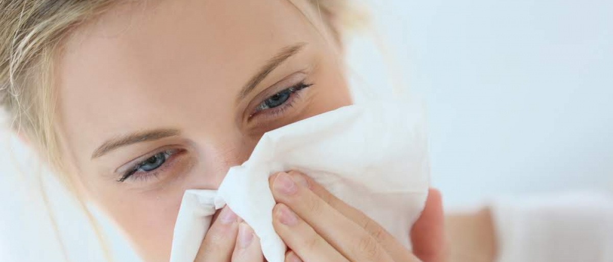 Eine Frau schneuzt sich wegen schwachem Immunsystem