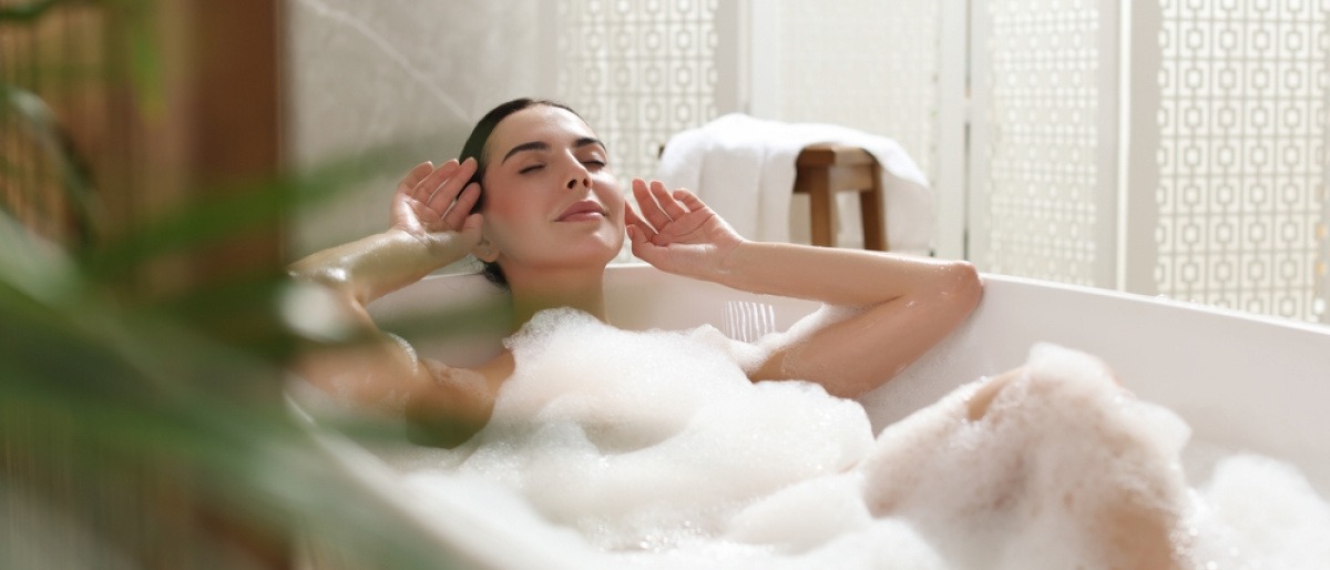 Eine Frau entspannt in der Badewanne für Selfcare