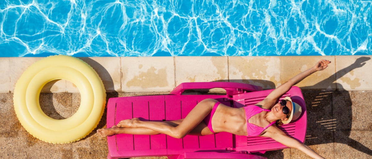 Frau am Pool beim Sonnen