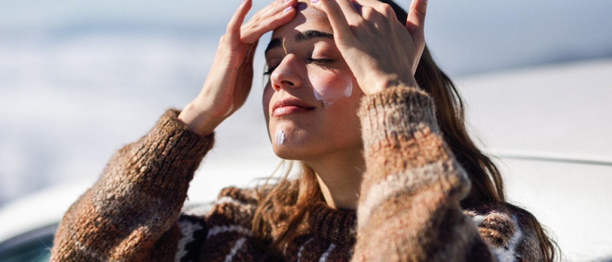 Frau mit Sonnencreme im Gesicht