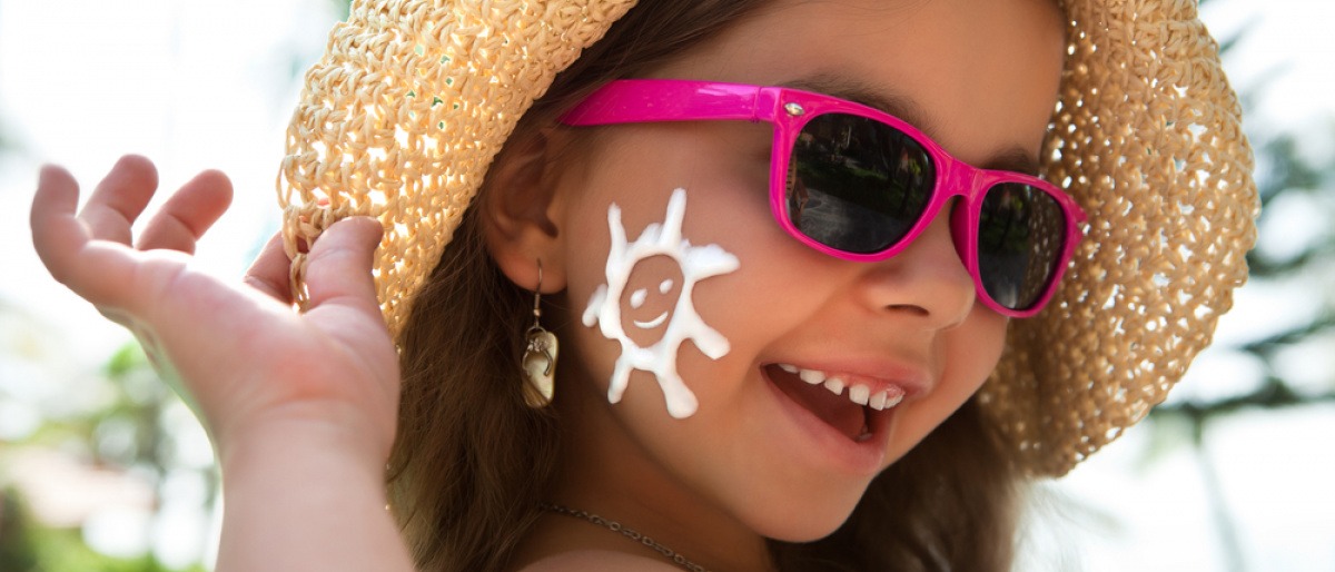Auf der Wange eines Mädchens ist Sonnencreme für Kinder