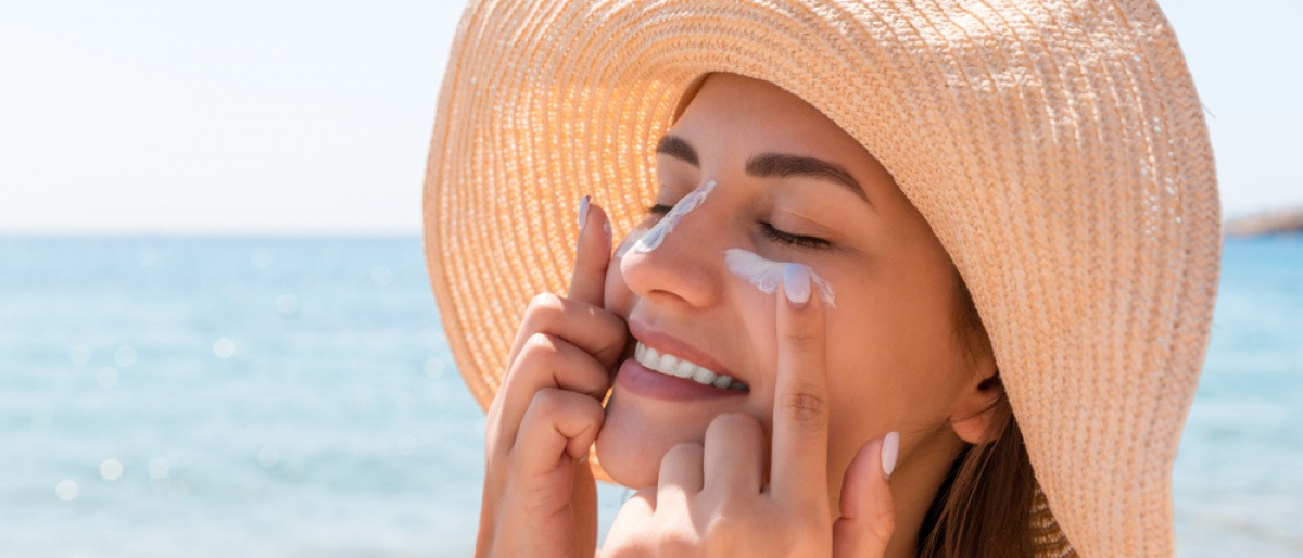 Junge Frau mit Sonnencreme im Gesicht.