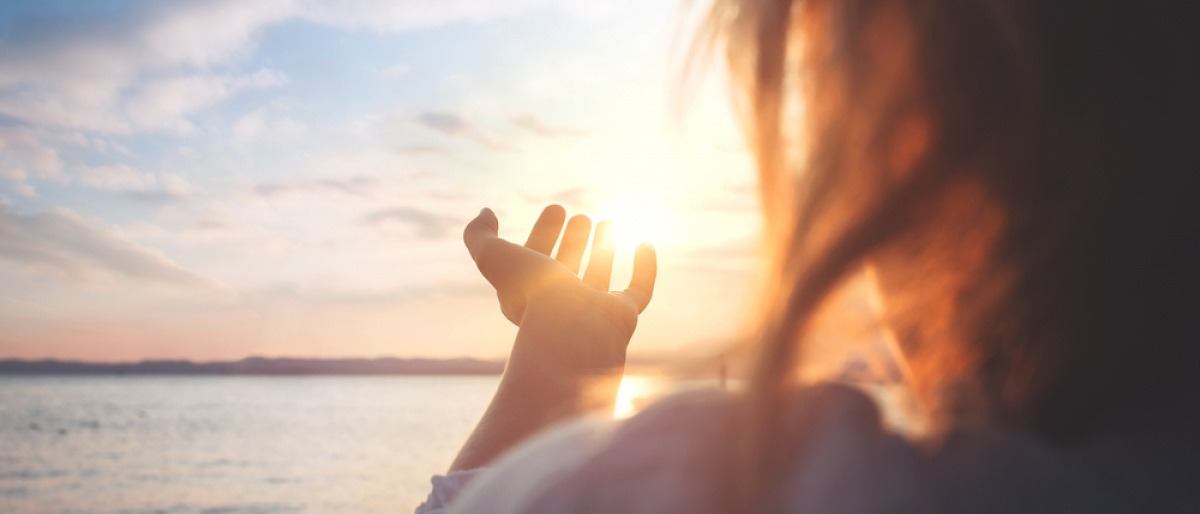 Eine Frau steht vor einer Sonne