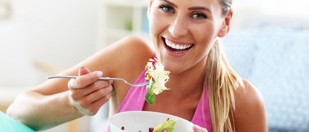 Eine Frau isst neben Sport vegane Ernährung