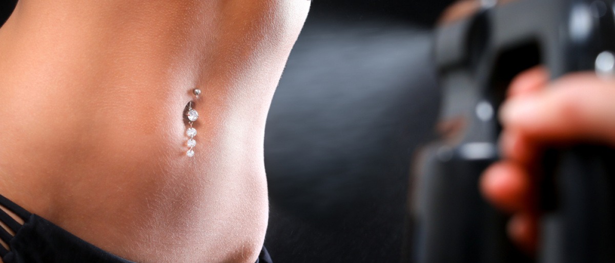 Ein Bauch wird mit Spray Tanning gebräunt