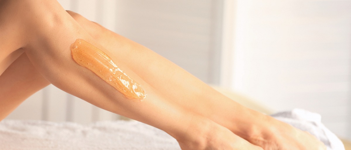 Eine Frau hat eine Sugaringpaste auf den Beinen 