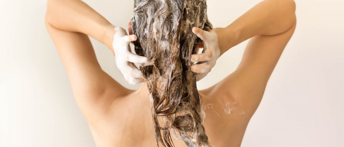 Eine Frau wäscht ihre Haare, täglich oder weniger oft