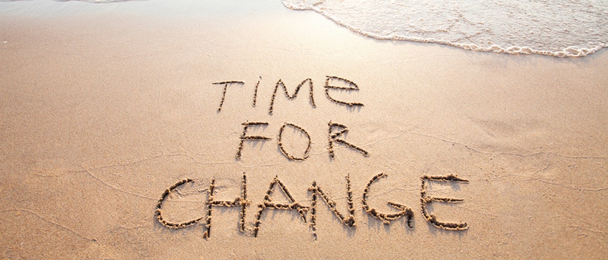 Auf einem Strand steht im Sand Time for Change