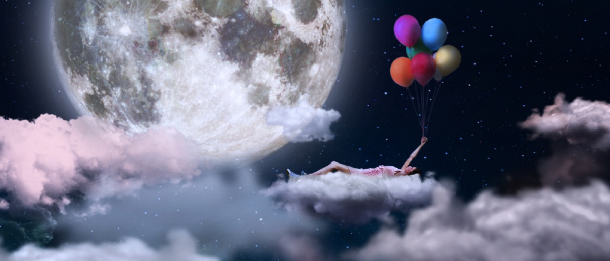 Traumbild einer Frau auf Wolken mit Ballons
