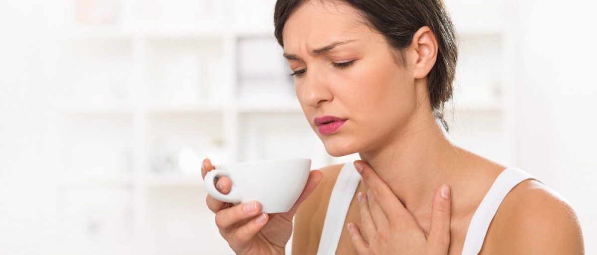 Eine Frau hat Halsschmerzen durch trockene Atemwege