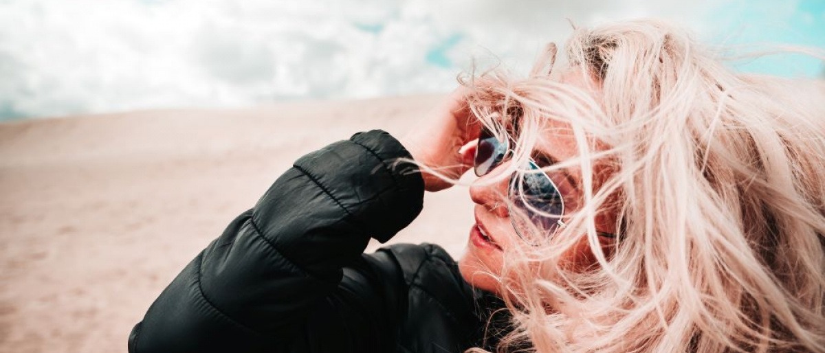 Frau mit Winterjacke und trockener Haut im Wind