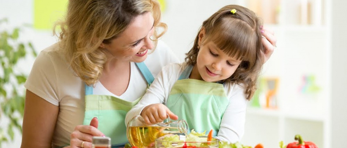 Eine Frau bereitet mit einem Mädchen vitaminreiche Ernährung für ein starkes Immunsystem zu