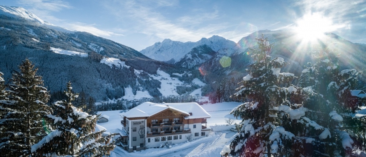 Ein Hotel inmitten einer verschneiten Berglandschaft. Hier kannst du natürlich auch wandern, Winter ist hier gleichbedeutend mit kalter Sommer.   