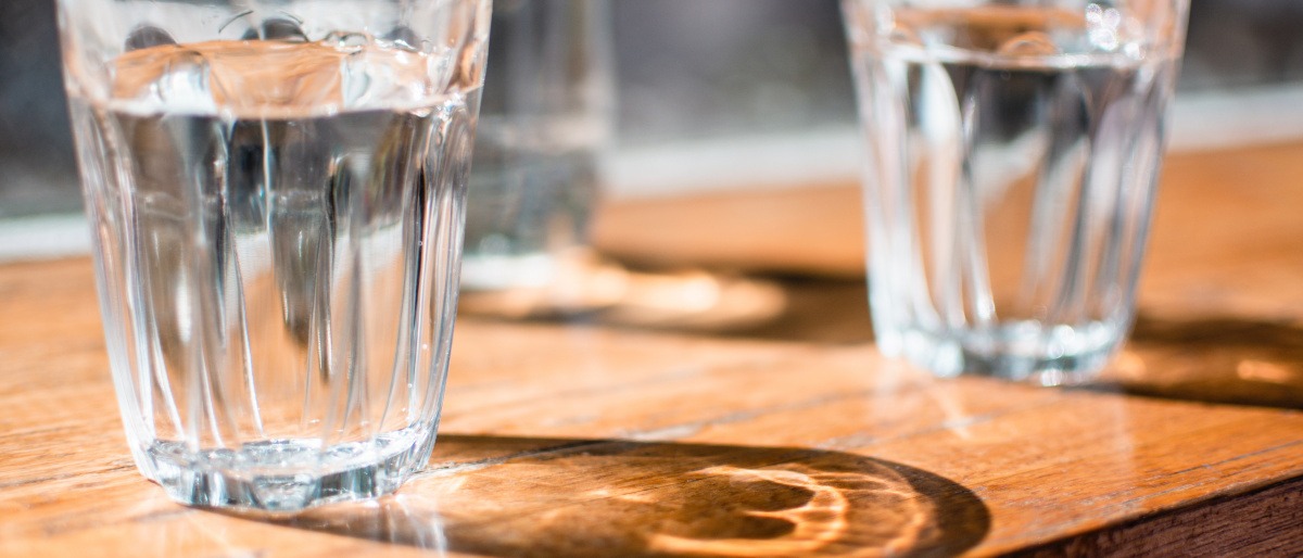 Zwei Gläser mit Wasser zum Trinken stehen auf einem Tisch