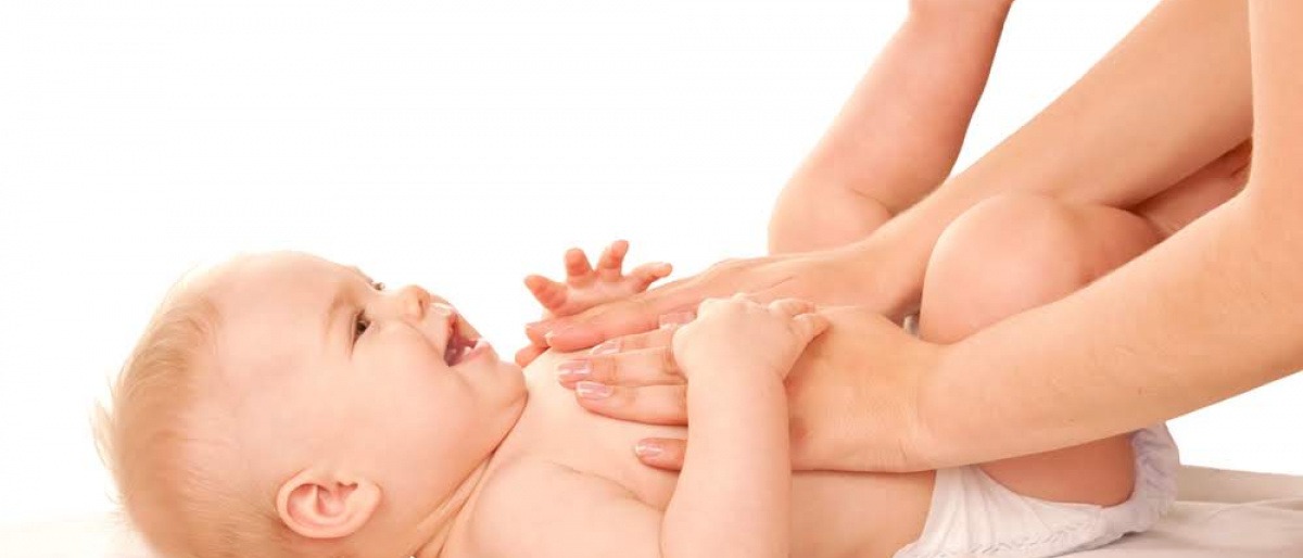 Eine Frau wickelt den Po eines Babys