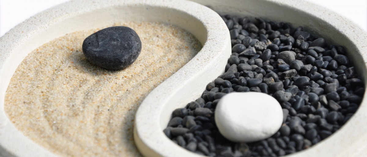 Ein Yin-Yang Symbol wird mit Sand und Steine dargestellt