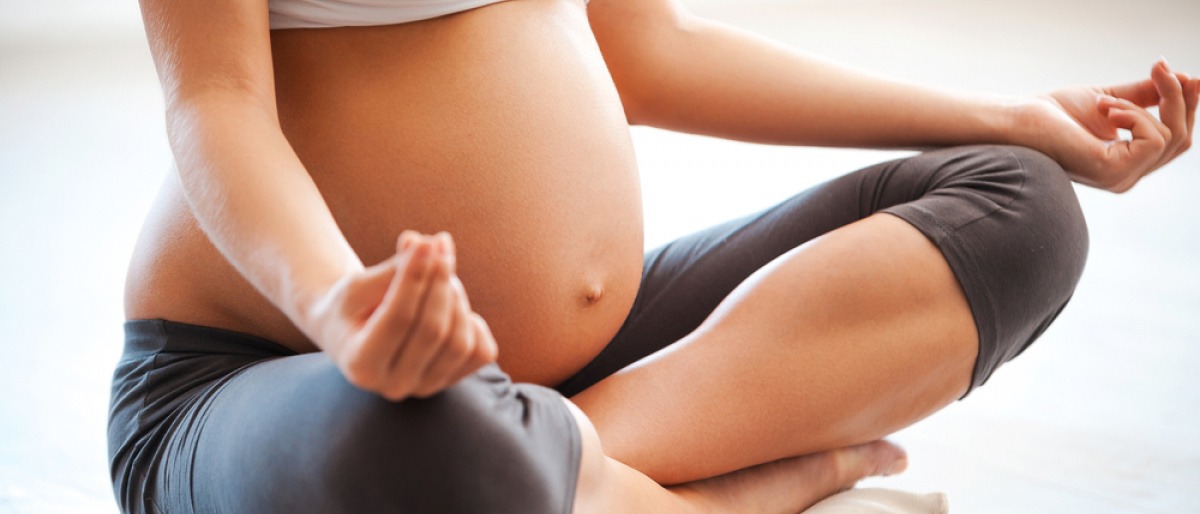 Eine schwangere Frau macht Yoga für Schwangere