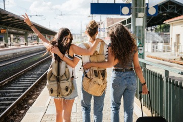 Drei Frauen am Bahnhof in einer Großstadt