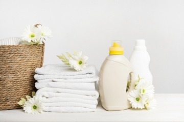 Flaschen mit Weichspülern stehen neben Handtüchern