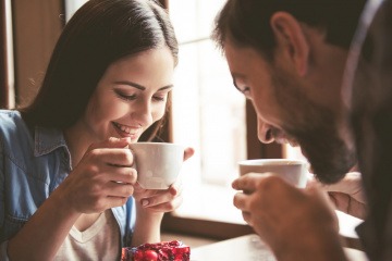 Mann und Frau beim Kaffeetrinken wirken glücklich