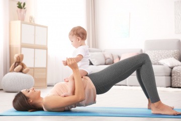 Frau trainiert ihren Beckenboden nach der Geburt mit Baby
