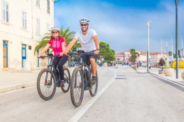 Zwei Urlauber sind auf einem E-Bike unterwegs