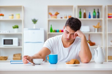 Mann schläft am Frühstückstisch durch Lebensmittel, die müde machen