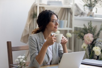 Frau bei der Pause während der Büroarbeit trinkt Kaffee