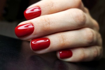Frau mit roten Nägeln und Russian Manicure