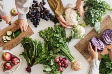 Menschen schneiden herbstliches Gemüse für das Essen