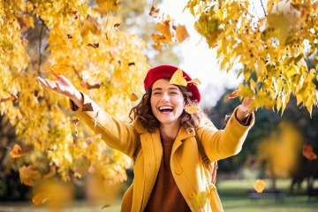 Strahlende Frau mit offenem Outfit im Herbst