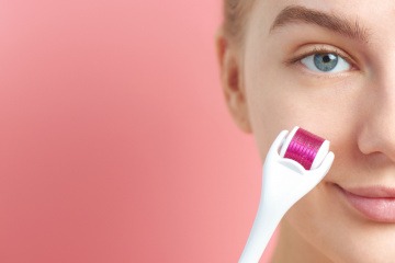 Eine Frau nutzt einen Dermaroller für das Microneedling zuhause.