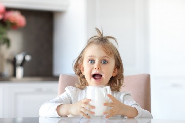 Kind trinkt Milch als calciumreiches Lebensmittel