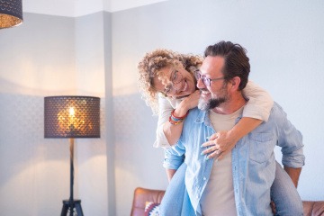 Glückliche Frau ist am Rücken eines lächelnden Mannes