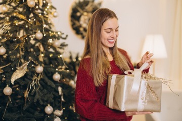 Frau packt zufrieden ein Geschenk aus