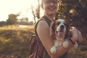 Ein Hund befindet sich in den Armen einer Frau