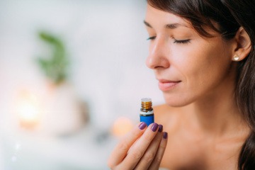 Frau riecht an einem ätherischen Öl