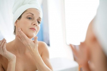 Eine Frau gibt Anti-Aging Öl in ihr Gesicht