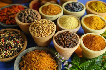 Es befinden sich verschiedene bunte Ayurveda-Gewürze in runden Schüsseln