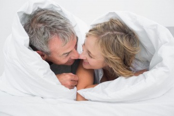 Ein Mann und eine Frau in den Wechseljahren im Bett
