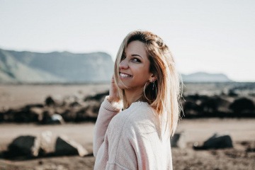 Eine Frau mit langen braun gesträhnten welligen Haaren