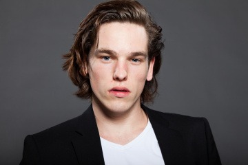 Ein Mann mit einer Kurzhaarfrisur, trägt den neuesten Frisurentrend namens Bro Flow, wo die Hauptpartie lange und die Seiten gleichmäßig kurz gehalten wird