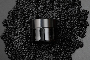 Cremetiegel auf schwarzem Kaviar