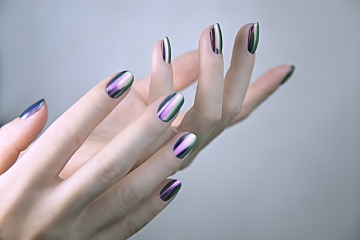 Finger sind mit Chrome Nails geschmückt