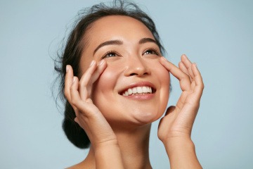 Eine Frau mit Make-up Cloud Skin lächelt 