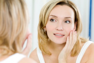 Eine Frau gibt Gesichtpflege mit dem Coenzym Q10 ins Gesicht