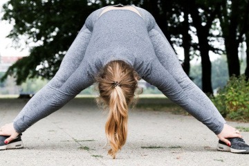 Eine Frau dehnt sich beim Joggen