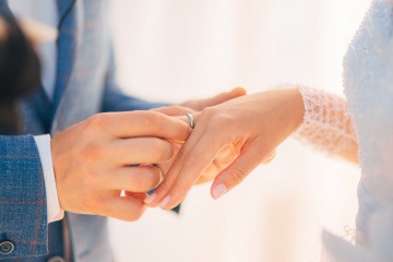 Ein Mann steckt einer Frau einen Ehering auf den Finger